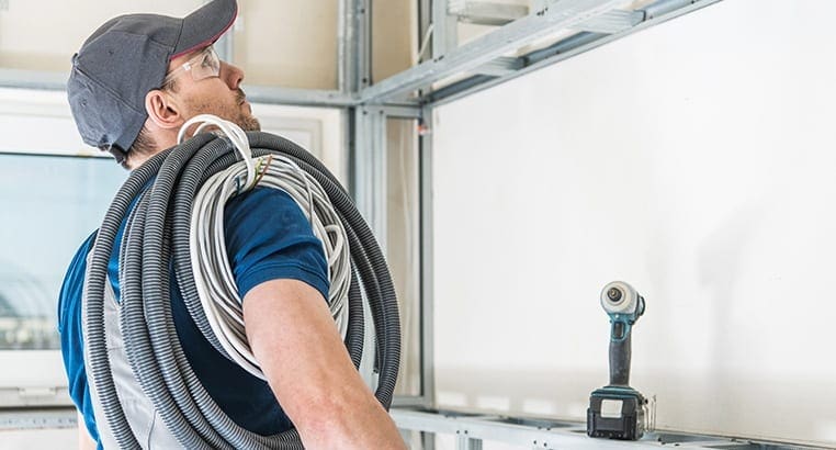 Electrician with cables around their shoulder